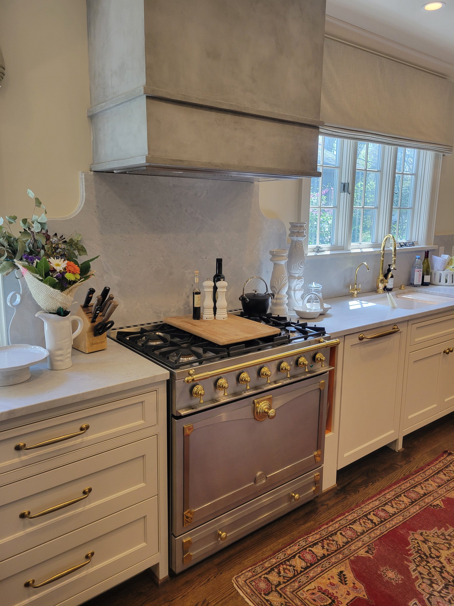 White custom kitchen with brass La Cornue range by Keeler Carpentry